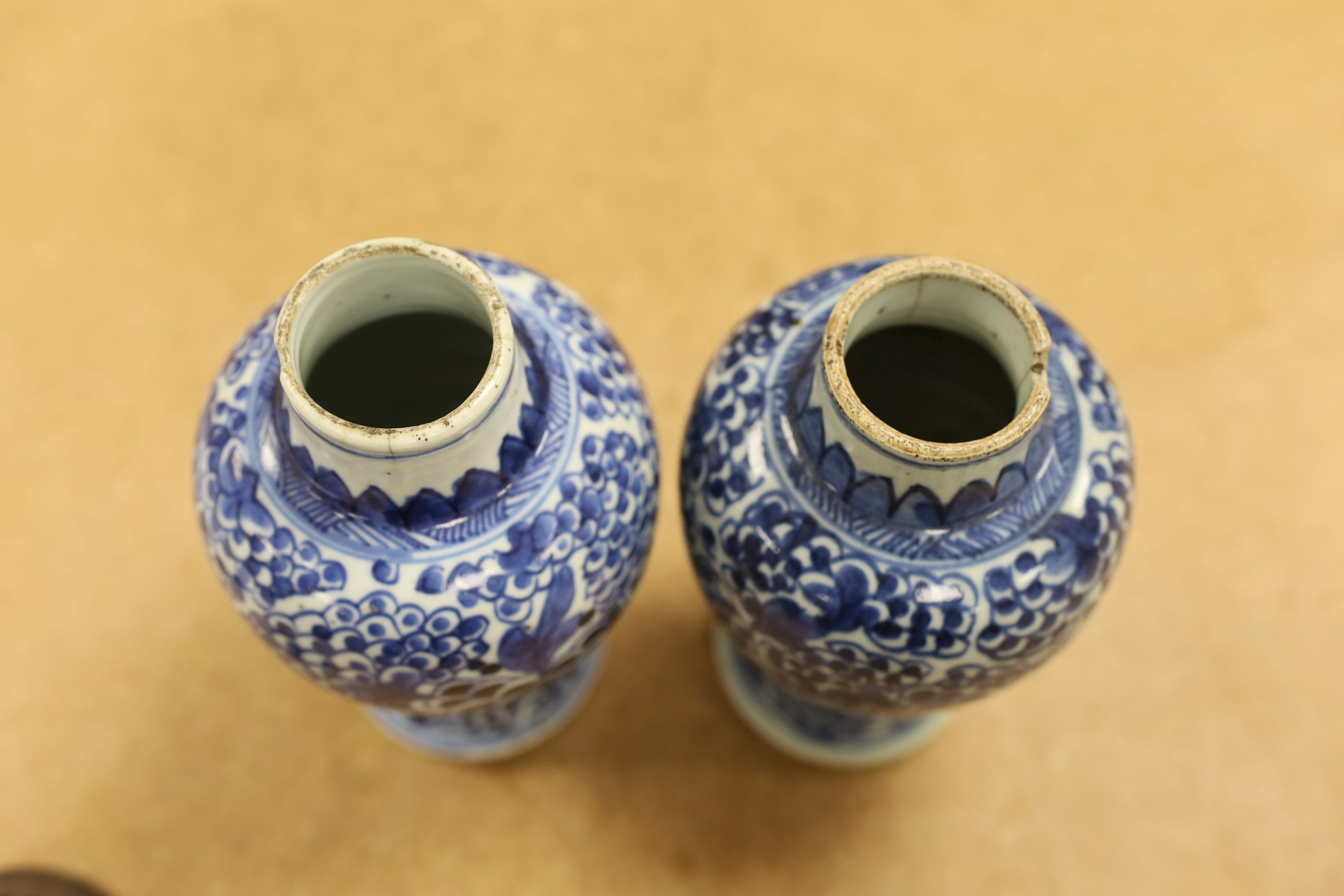 A pair of Chinese blue and white 'phoenix' vases, Kangxi, associated wood covers, 19cm including covers